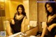 A woman in a black dress standing in front of a mirror.