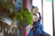 A woman in a blue dress sitting on a balcony.